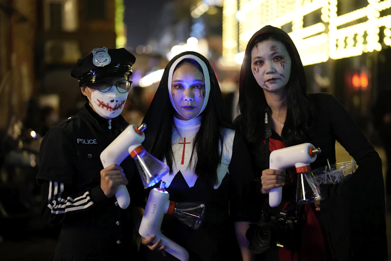 Three people in costumes pose for a photo in Seoul, South Korea.
