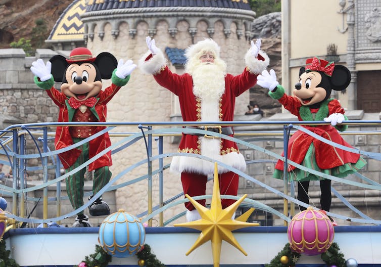 Disney characters Mickey and Minnie Mouse perform with Santa Claus