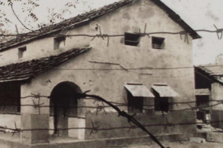 A sepia photograph of a large white building where Chinese people were held after the Sino-Indian conflict.