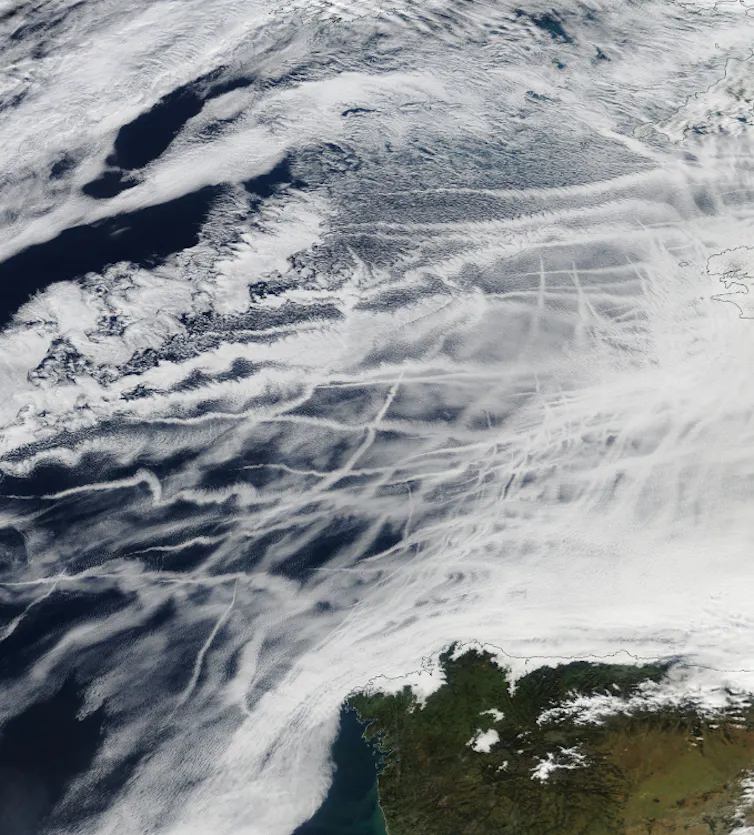A satellite image showing white streaks of cloud over the ocean.