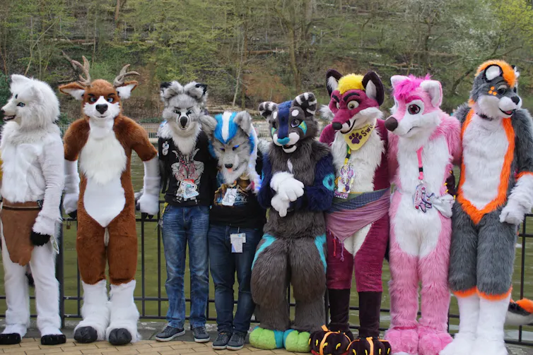 A group of people in furrey costumes take a photo together.