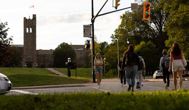 Students seen crossing the street at a light.