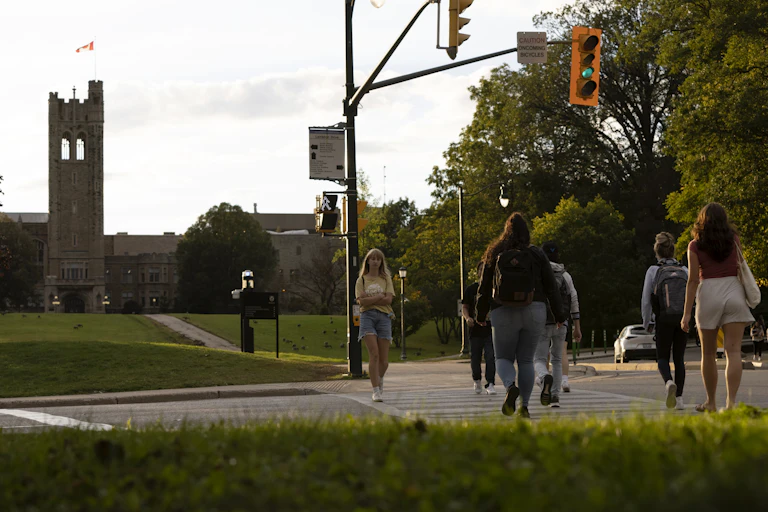Students seen crossing the street at a light.
