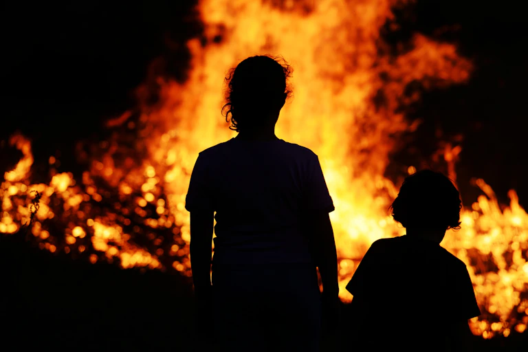 Children looking at large fire