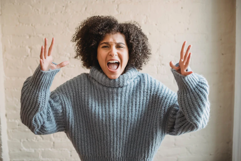 An angry woman throws her hands in the air