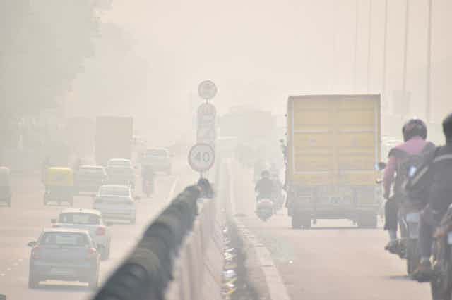 Two lanes of a motorway shrouded in smog.
