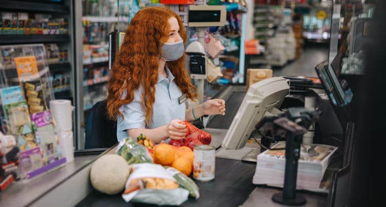 Woman working on supermarket checkout