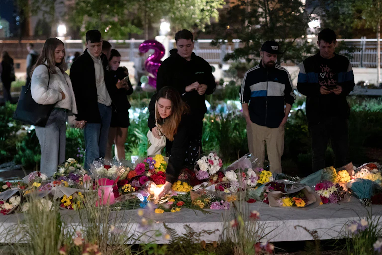 People laying flowers and paying their respects at the memorial for victims of the Manchester arena bombing.