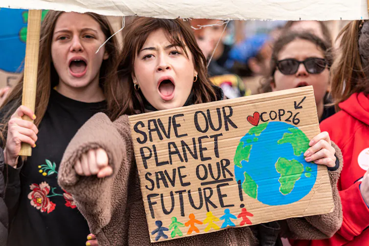 Young protester holds sign saying 'save our planet save our future'