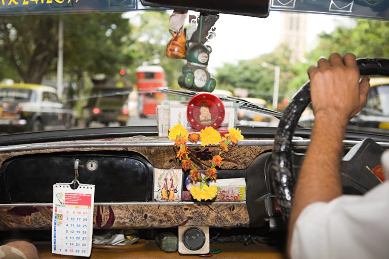 Inside of a taxi showing various sacred objects.