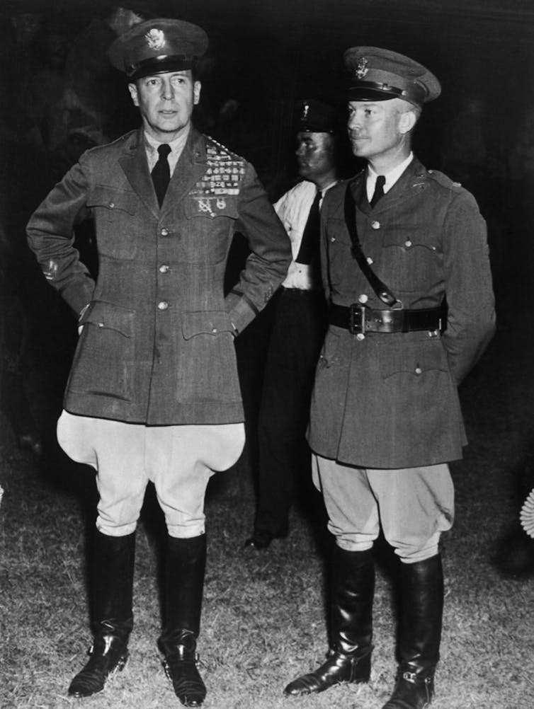 Two white men dressed military uniforms are standing next to each other.