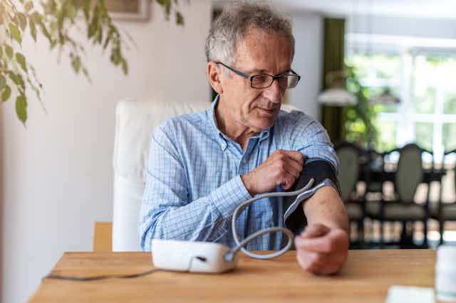 A man takes his own blood pressure at home.