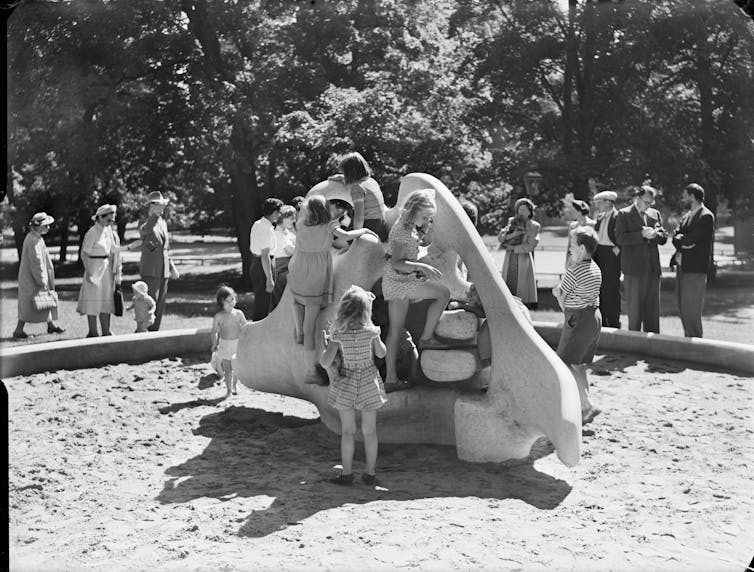 Kids play on a concrete sculpture.