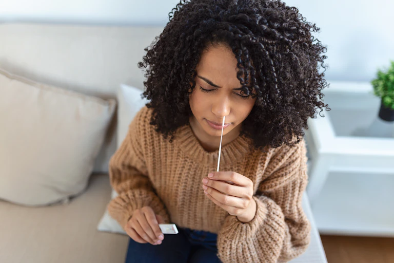 Woman swabs her nose for a COVID test