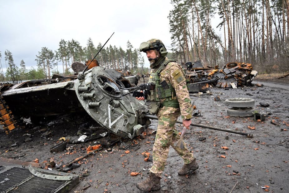 Militaire devant des chars détruits