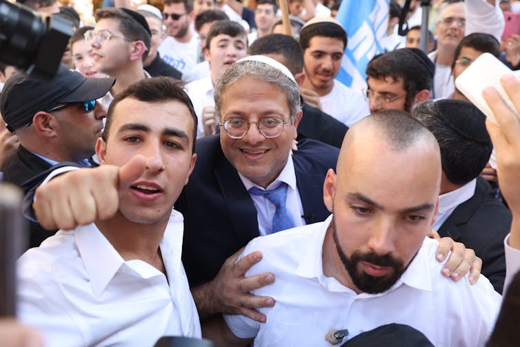 Israeli MP and leader of far-right Otzma Yehudit (Jewish Power) party Itamar Ben Gabir (C) greets supporters during a campaign event in Jerusalem, October 2022.