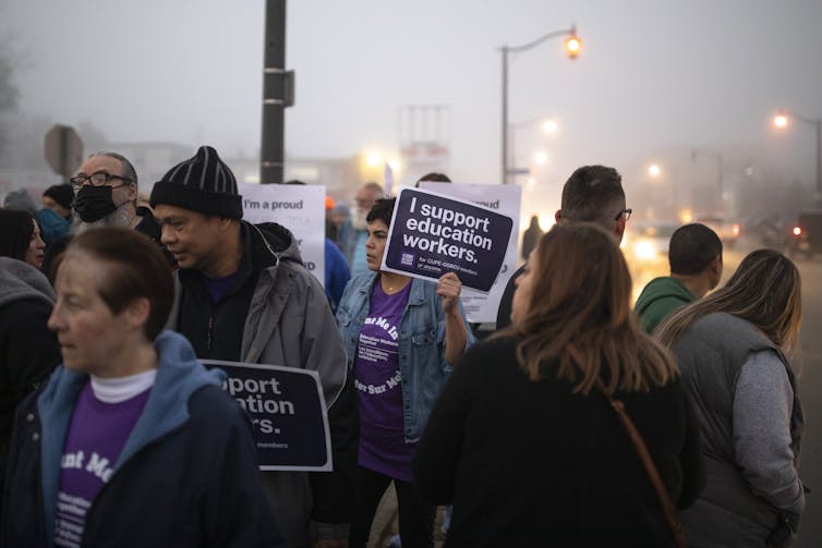 People seen in fog with picket signs.