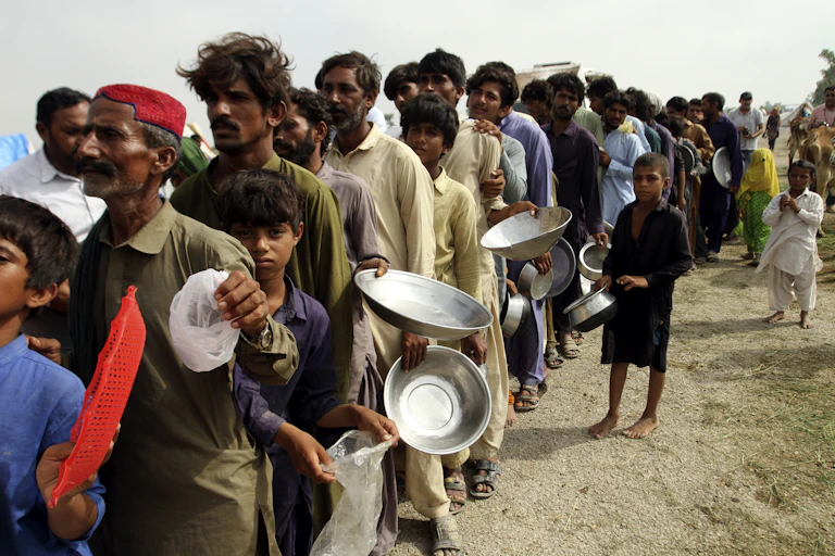 People in Pakistan line up with empty plates