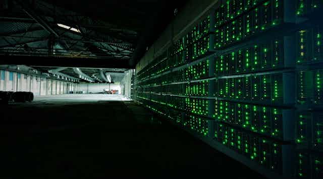 Hangar sombre avec les lumière de nombreux serveurs informatiques empilées
