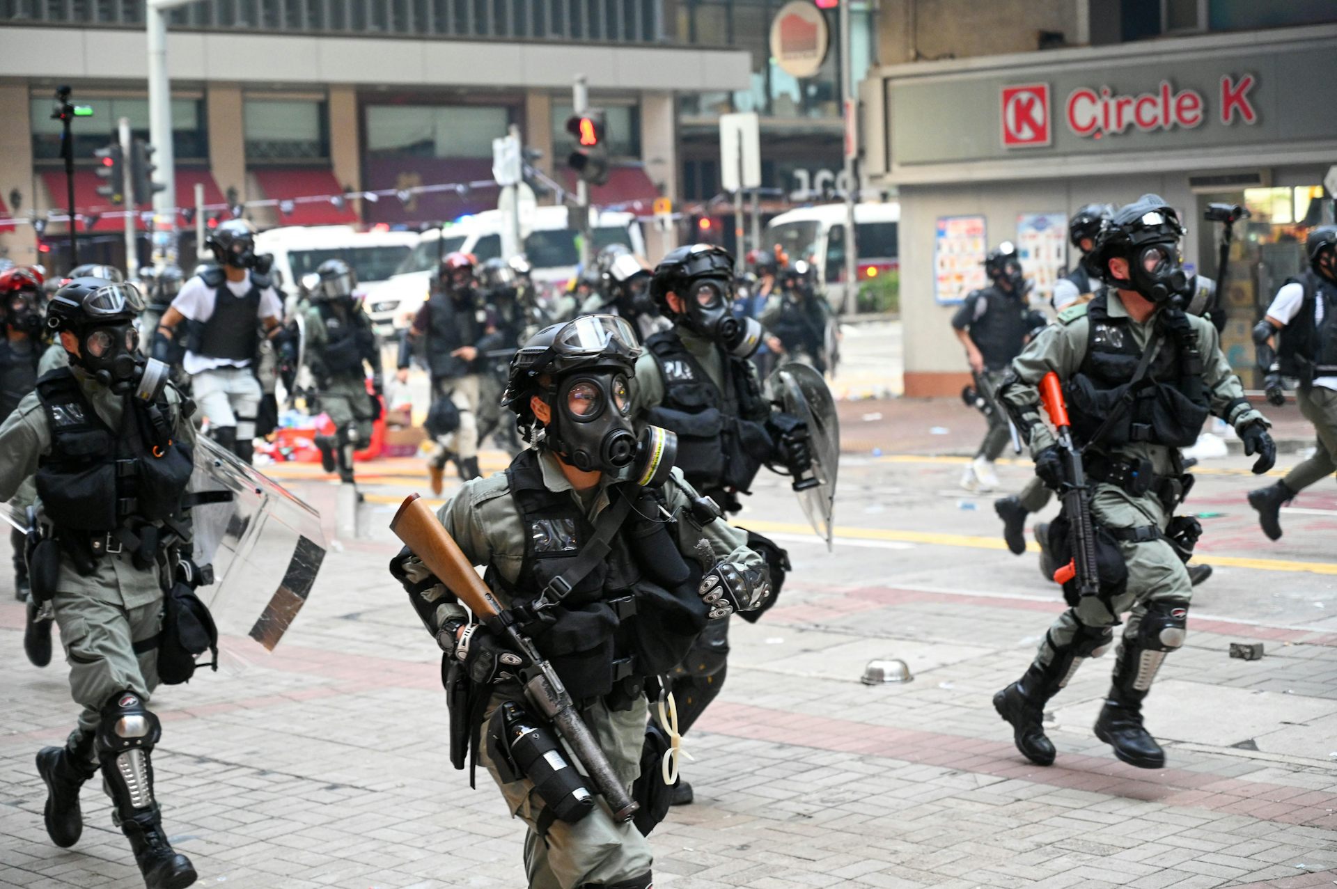 Police carrying weapons fire tear gas at protesters.
