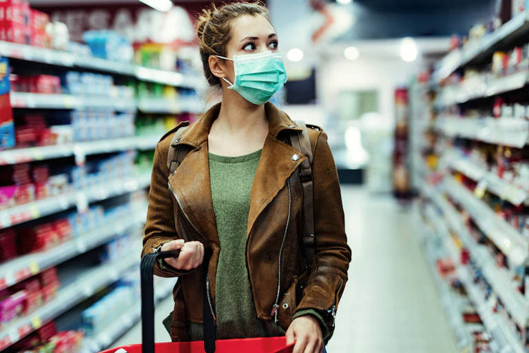 femme dans une allée de supermarché qui porte un masque