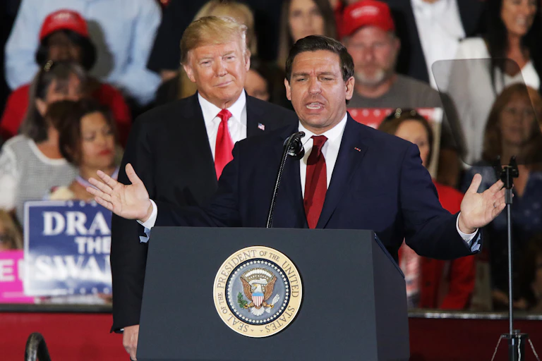 Donald Trump stands behind Republican politician Ron DeSantis at a rally in his campaign for governbor of Florida in 2018