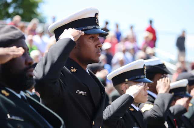 Soldiers in uniform saluting. 