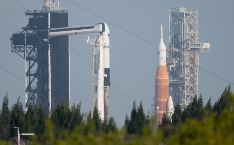 Two rockets on launch pads in the distance.