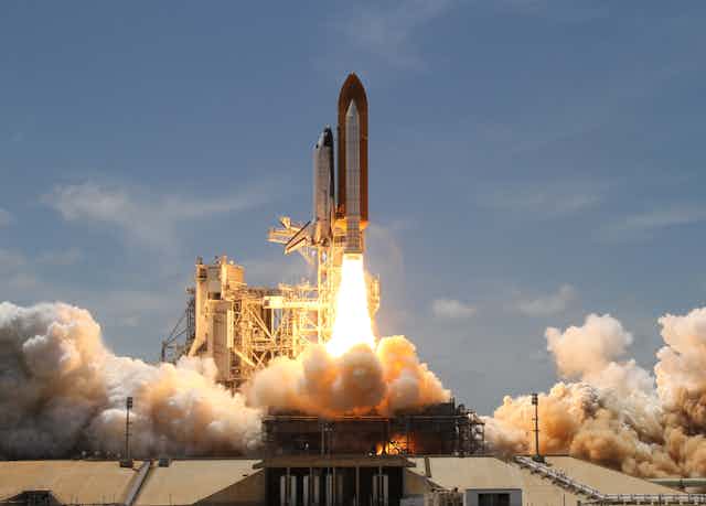 A rocket with a shuttle taking off.