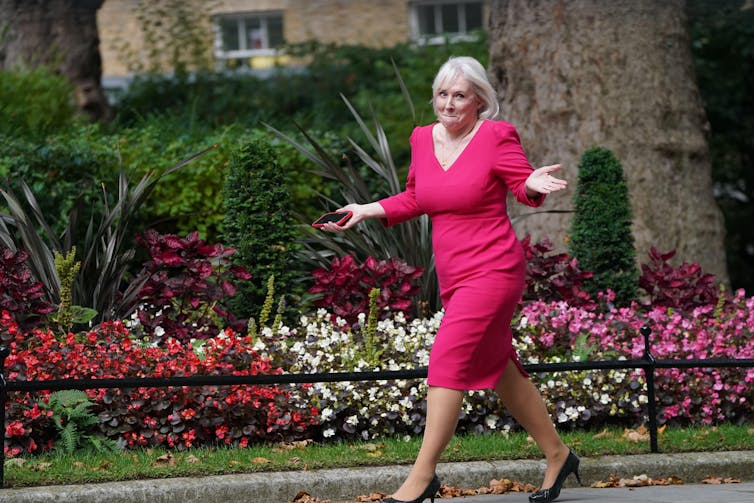 Nadine Dorris shrugs and looks surprised as she walks down Downing Street.