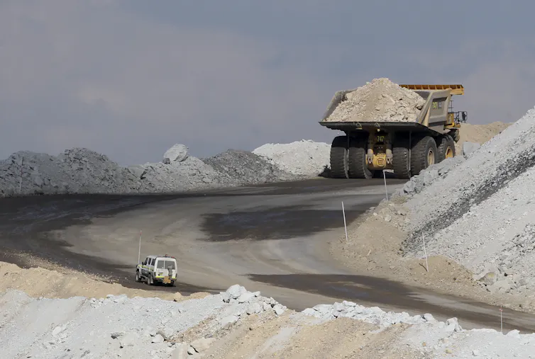 vehicle follows large coal truck up hill