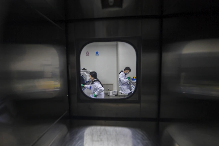 scientists in secure lab through window