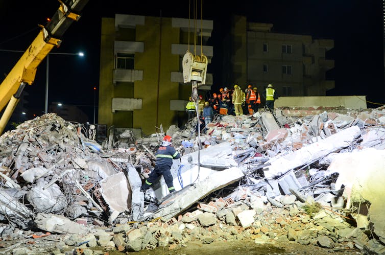 A digger tackling rubble caused by an earthquake.