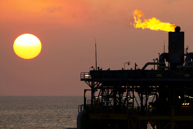 Gas flares from an offshore gas platform at dusk.