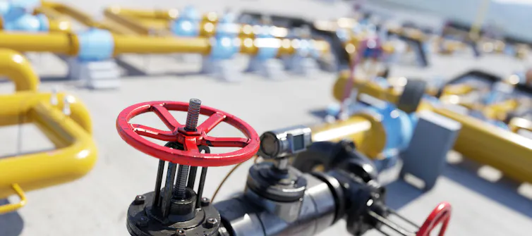 A red valve on yellow gas distribution pipes.
