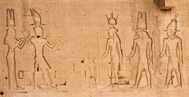 A wall engraving at the temple of Hathor at Dendera showing Cleopatra and her son on the left, looking at three gods on the right