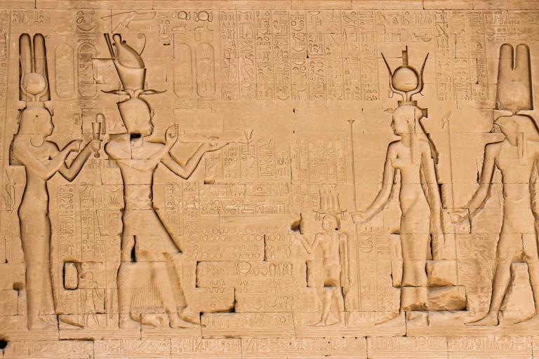 A wall engraving at the temple of Hathor at Dendera showing Cleopatra and her son on the left, looking at three gods on the right