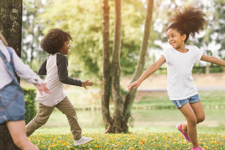 Three children are playing outside on a sunny day.