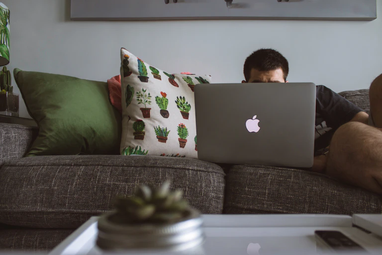 Man lays on laptop working on his computer