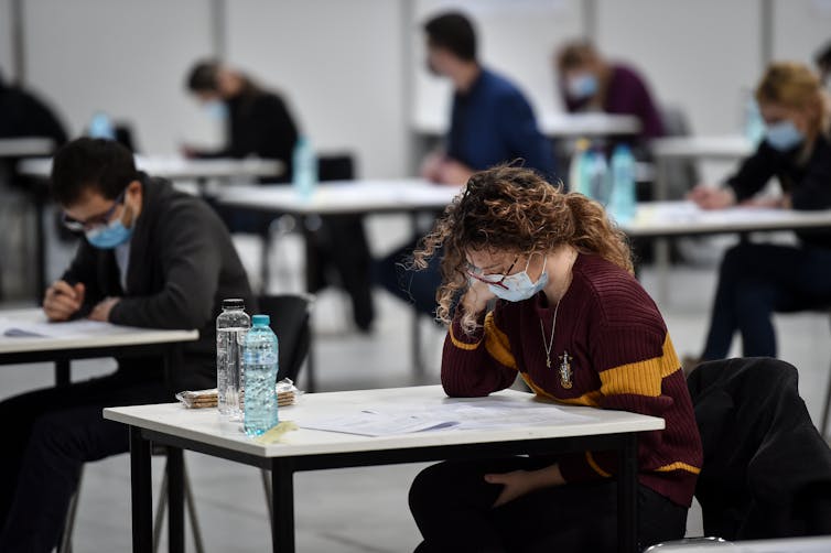 Students sitting at separated desks for an exam.