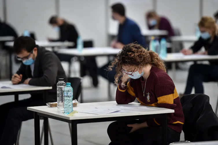 Students sitting at separated desks for an exam.
