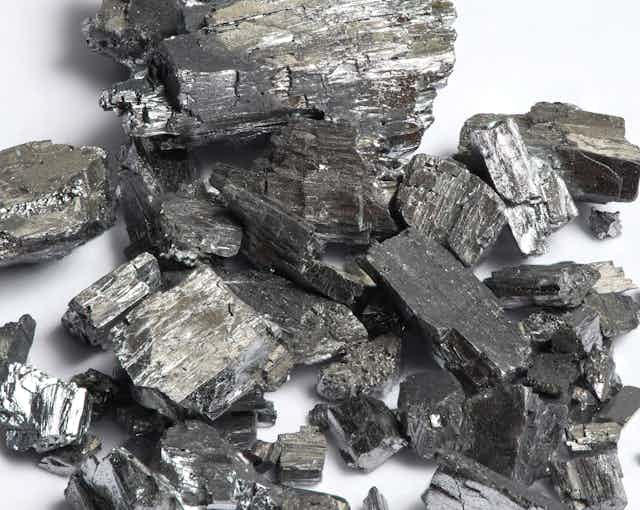 A pile of silvery-grey crystals of tellurium.
