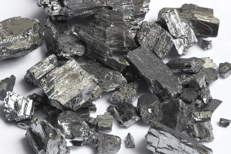 A pile of silvery-grey crystals of tellurium.