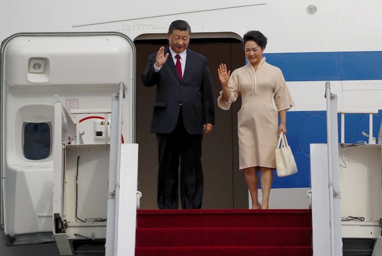 Chinese President Xi Jinping (L) and his wife Peng Liyuan disembark from their plane as they arrive at Ngurah Rai International Airport ahead of the G20 Summit in Bali, Indonesia, 14 November 2022.