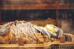 The mummy of an ancient Egyptian woman decorated with gold and enamel in the Egyptian Museum in Cairo