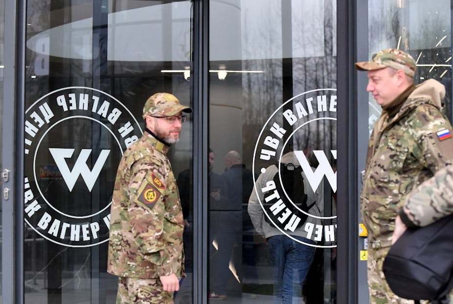 Deux hommes en uniforme de camouflage devant le siège de Wagner à Moscou