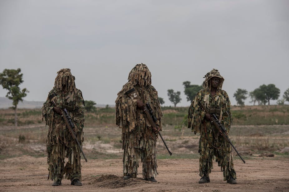 Men in military camouflage, holding rifles