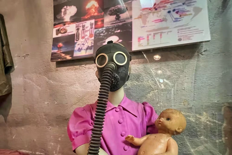 Mannequin in gas mask holding a baby doll
