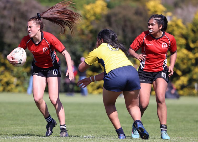 Young women playing rugby