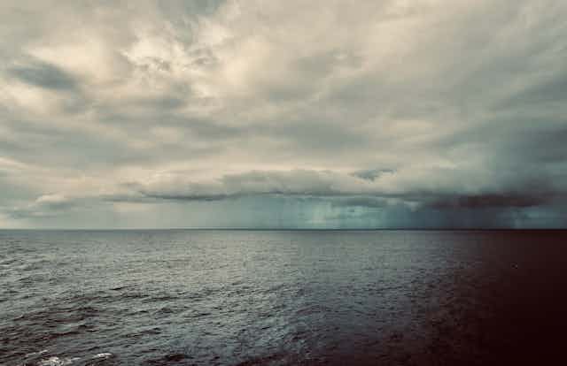 storm clouds hover over ocean
